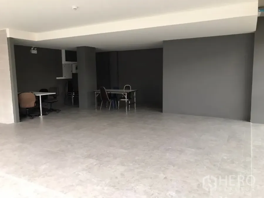 Retail Space for rent in Khlong Toei, Bangkok - Open-plan retail space with gray tiled floors and dark feature walls.
