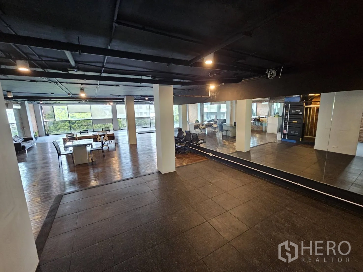Office Space for rent in Watthana, Bangkok - Mirrored wall facing an open workspace with server cabinet, seating and wide windows.