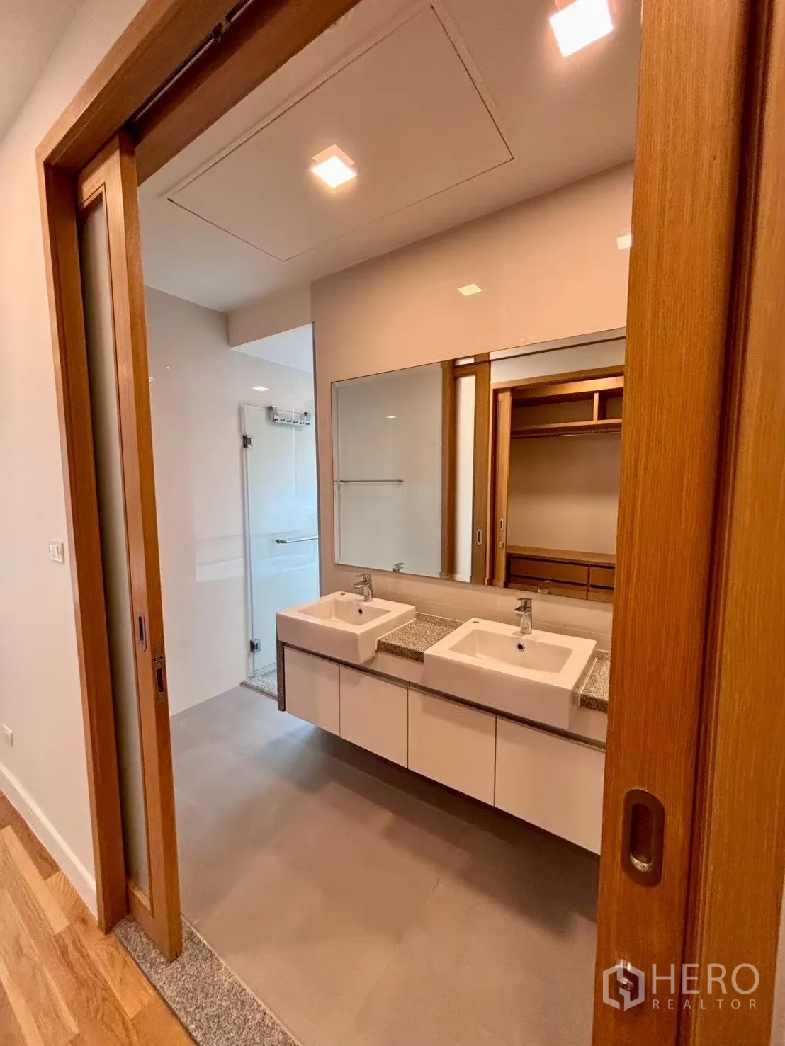 Condominium for rent in Khlong Toei, Bangkok - Bathroom entry with twin vanities and large mirror next to closet