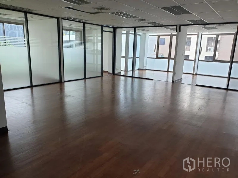 办公空间 出租在Khlong Toei, Bangkok - 宽敞的办公室楼层，磨砂玻璃隔断、木地板与格栅吊顶照明
