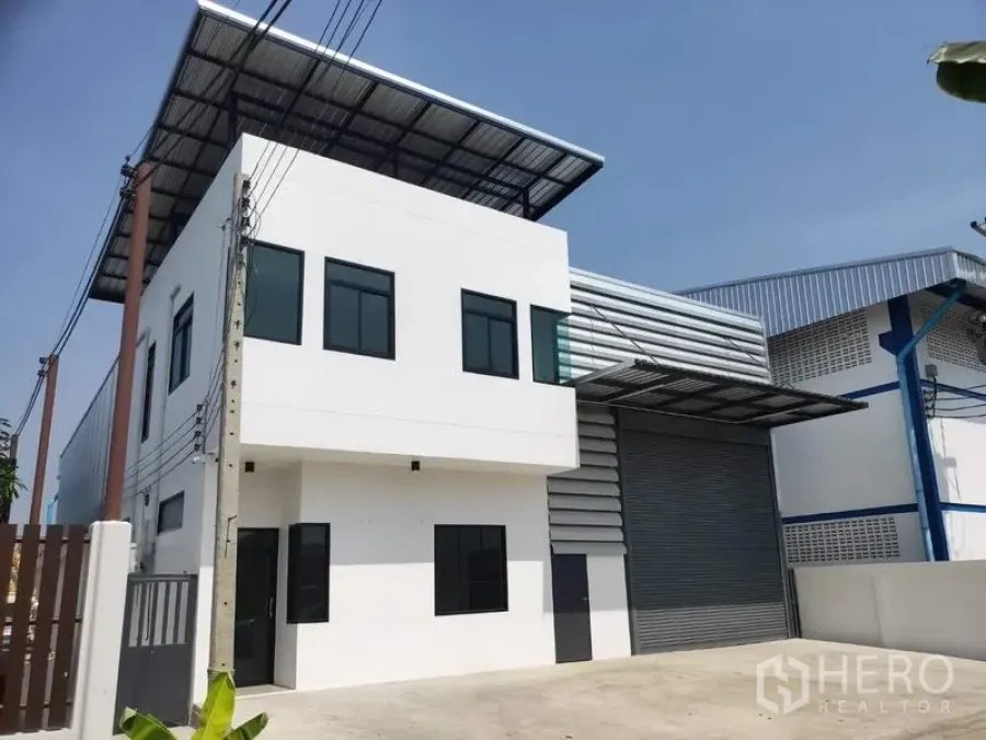 Factory for rent in Lam Luk Ka, Pathum Thani - Modern two-storey factory with white office block and large roller shutter in Lam Luk Ka.