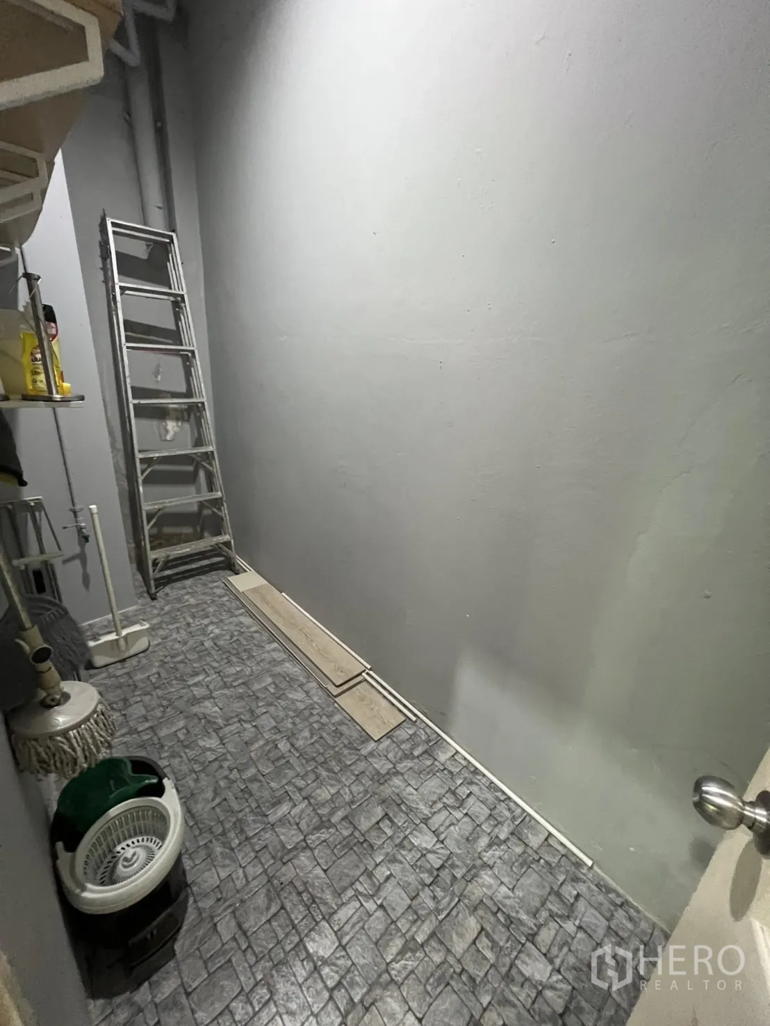 Retail Space for rent in Watthana, Bangkok - Back‑of‑house storage room with stone‑pattern floor, shelves and a ladder.