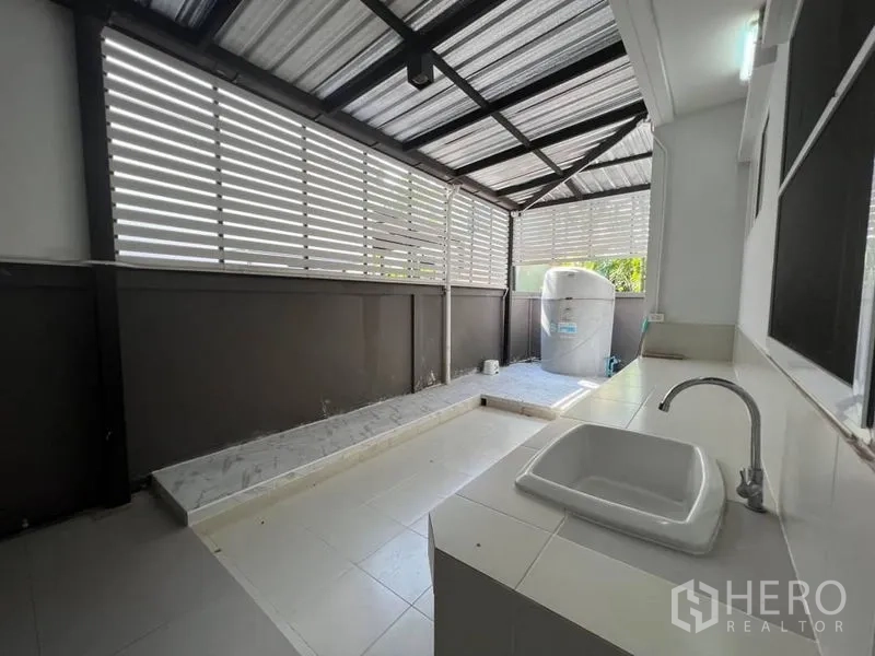 Detached House for rent or sale in Bang Phli, Samut Prakan - Covered service area with tiled floor, utility sink and louvered privacy panels.