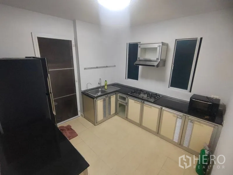 Detached House for rent in Prawet, Bangkok - Separate kitchen with stainless counters, gas hob, sink and range hood.
