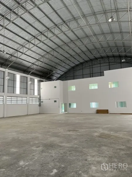 Factory for rent or sale in Bang Bo, Samut Prakan - Expansive warehouse floor facing the internal office mezzanine and high roof structure.