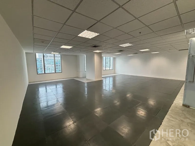 Office Space for rent in Watthana, Bangkok - Open-plan office with raised access floor, grid ceiling lights, white walls, and large windows with Sukhumvit city views.