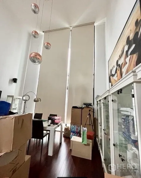 Home Office for rent in Watthana, Bangkok - Double-height room with tall blinds, pendant lights and display cabinets.