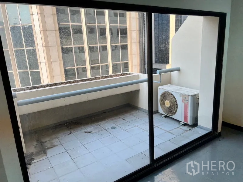 Office Space for rent in Pathum Wan, Bangkok - Compact balcony with AC condenser and city building views seen through floor-to-ceiling glass.