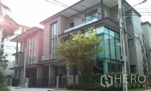 Townhouse for rent in Bang Kapi, Bangkok - Modern multi-storey townhouse exterior in Bang Kapi with large glass windows and gated entrance.