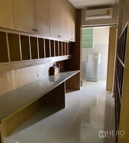 Office Space for rent in Din Daeng, Bangkok - Long storage corridor with built-in wooden shelves, glass countertop and air-conditioning leading to a pantry.