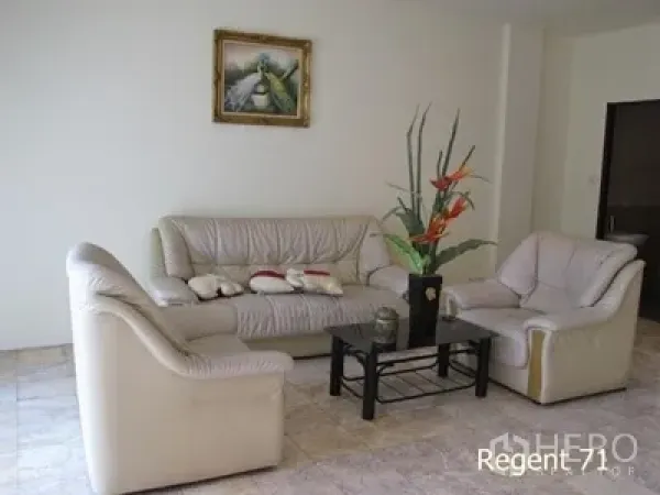 Townhouse for rent in Khlong Toei, Bangkok - Bright living room featuring a cream leather sofa set, glass coffee table, and tiled floor.