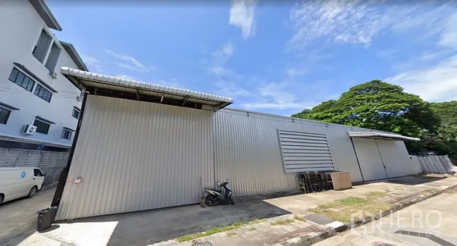 货栈 出租在Wang Thonglang, Bangkok - 金属外墙仓库外观，宽幅推拉门与便捷车道，蓝天与绿树相伴。