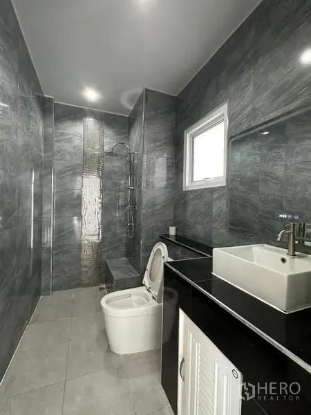 Detached House for sale in Lam Luk Ka, Pathum Thani - Modern bathroom with gray marble tiles, walk-in shower and vanity with square basin.