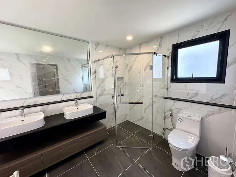Detached House for rent in Bang Phli, Samut Prakan - Contemporary bathroom featuring double vanity, glass shower and marble-look tiles.