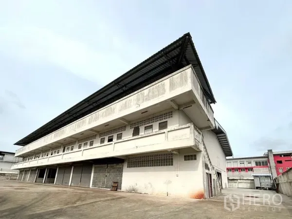 货栈 出租在Bang Khun Thian, Bangkok - 邦昆田多层仓库外观，金属屋檐外挑，设有多处装卸月台。
