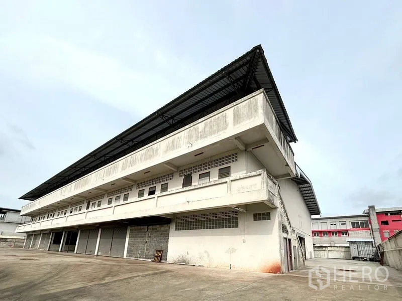 货栈 出租在Bang Khun Thian, Bangkok - 邦昆田多层仓库外观，金属屋檐外挑，设有多处装卸月台。