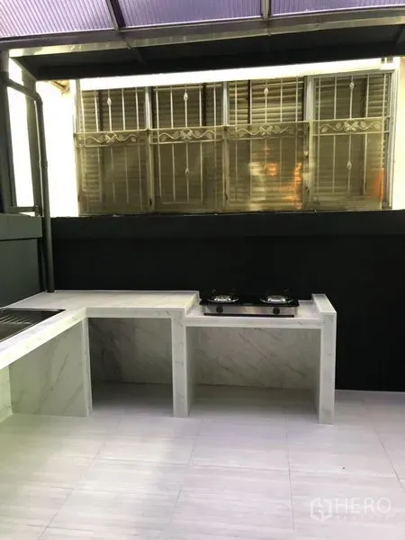 Townhouse for rent in Bang Kapi, Bangkok - Covered Thai kitchen and utility terrace with marble counters, gas hob and tiled floor.