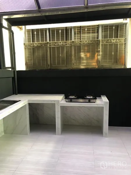 Townhouse for rent in Bang Kapi, Bangkok - Covered Thai kitchen and utility terrace with marble counters, gas hob and tiled floor.