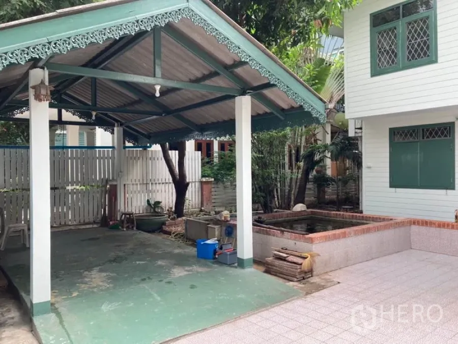 Detached House for rent in Sathon, Bangkok - Covered carport with decorative trim beside a small pond and lush greenery at a Sathon house.