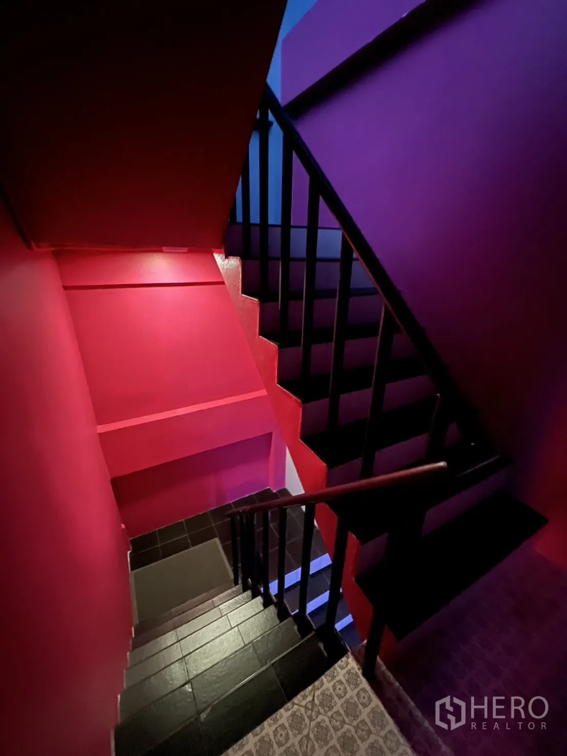 Shophouse for rent or sale in Watthana, Bangkok - Colorful stairwell painted pink and purple with black railings.