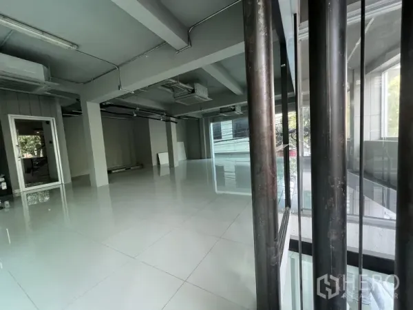 Retail Space for rent in Bang Rak, Bangkok - Bright retail unit viewed through a glass partition, showing open layout and tiled flooring.