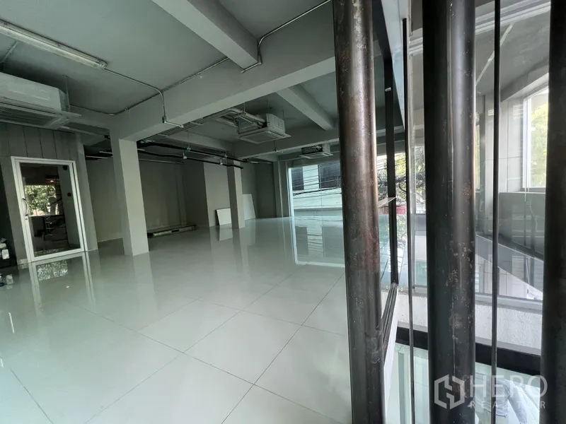 Retail Space for rent in Bang Rak, Bangkok - Bright retail unit viewed through a glass partition, showing open layout and tiled flooring.