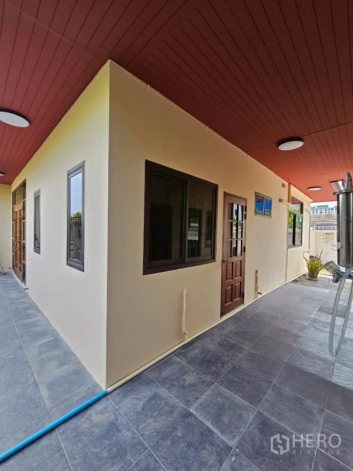 Home Office for rent in Wang Thonglang, Bangkok - Covered side walkway with red ceiling, gray floor tiles, windows and wooden doors.