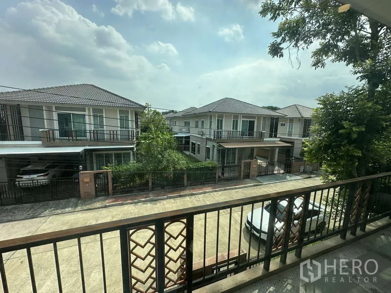 独立式住宅 出售在Sai Mai, Bangkok - 阳台俯瞰整洁的社区街道与邻居房屋。