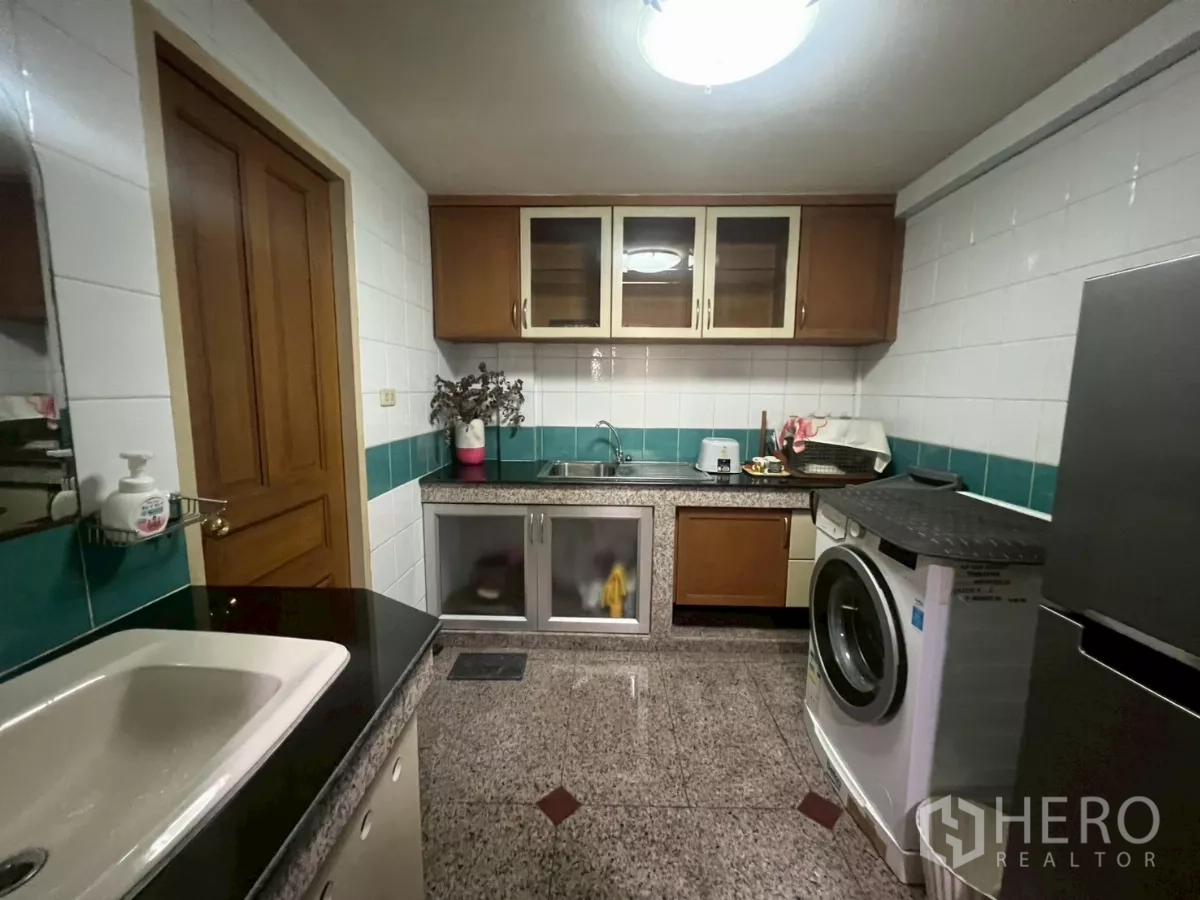 Shophouse for rent in Bang Rak, Bangkok - Compact service kitchen with granite counters, tiled splashback, sink and washing machine.