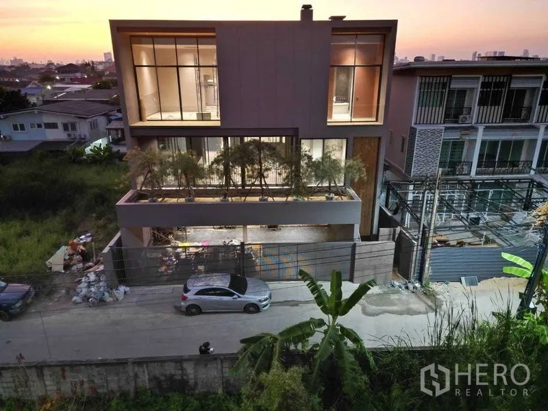 บ้าน ขายในLat Phrao, Bangkok - ด้านหลังบ้านสามชั้นสมัยใหม่ กระจกเต็มสูง ช่วงพระอาทิตย์ตก