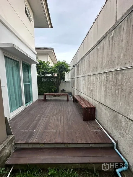 Detached House for sale in Prawet, Bangkok - Raised wooden deck with benches alongside the house.