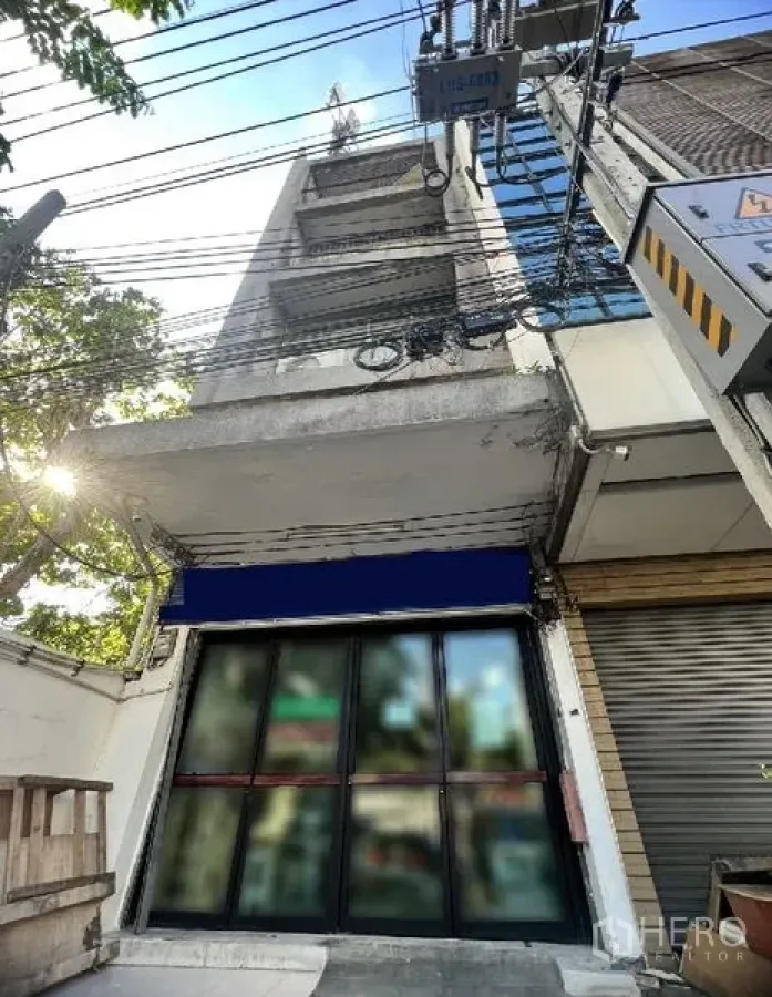 อาคารพาณิชย์ ให้เช่าในWatthana, Bangkok - ด้านหน้าอาคารพาณิชย์หลายชั้น หน้าร้านกระจกพร้อมกันสาดสีน้ำเงิน ตั้งอยู่ในซอยสุขุมวิทใกล้ BTS ทองหล่อ
