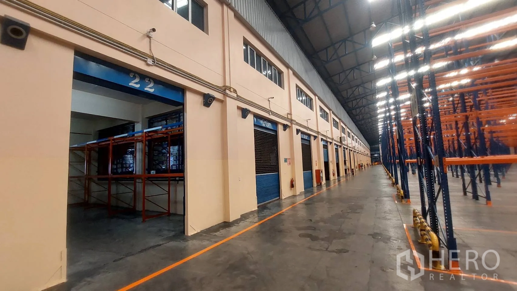 Warehouse for rent in Mueang Pathum Thani, Pathum Thani - Loading bay number 22 with roller shutters and racking in a high-ceiling warehouse.