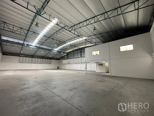 Factory for rent in Si Racha, Chon Buri - Bright warehouse interior featuring insulated roof panels, ventilation louvers and a mezzanine office section.
