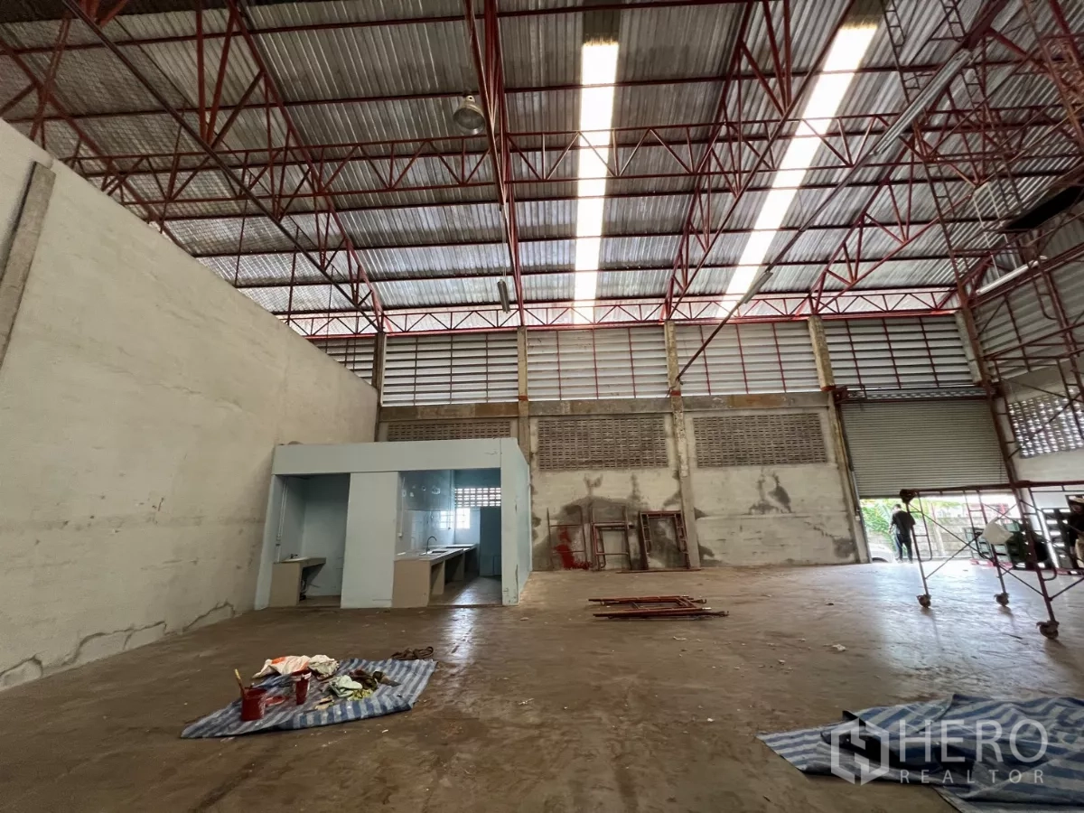 货栈 出租在Khlong Sam Wa, Bangkok - 开阔作业区，设工作台凹位与卷帘门通道。