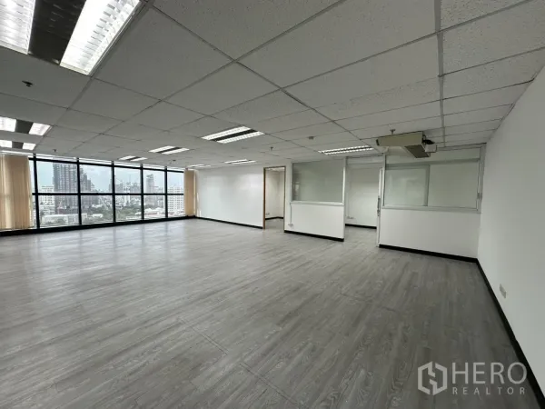Office Space for rent in Watthana, Bangkok - Spacious office hall featuring multiple glass-partitioned rooms, blinds and wall-to-wall windows.