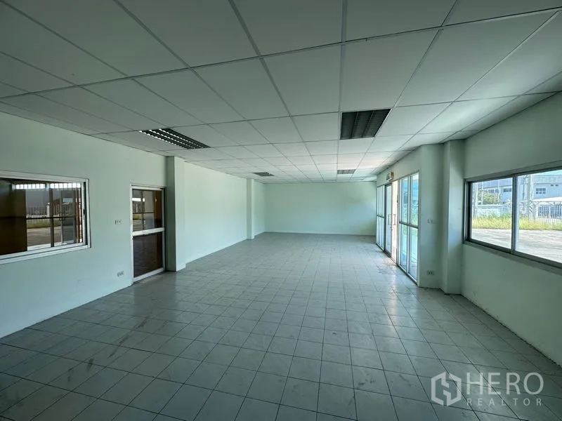 Factory for rent in Chon Buri - Ground-floor office or reception area with glass entrance doors and large windows facing the yard.