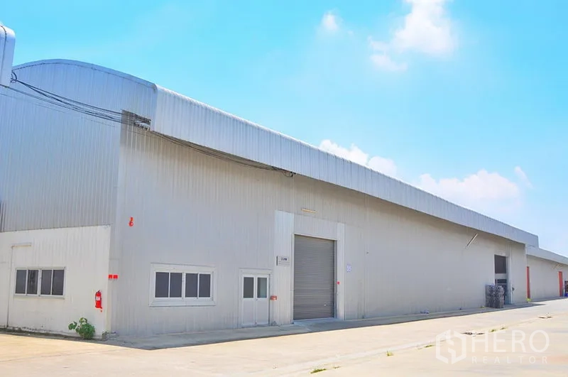 Warehouse for rent in Lat Krabang, Bangkok - Side exterior of warehouse with roller shutter, office windows and fire safety points