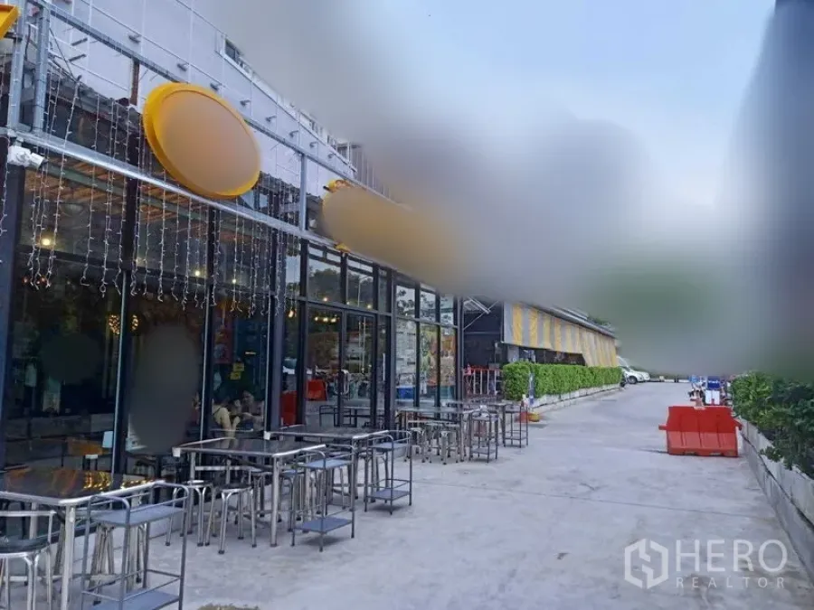 Retail Space for rent in Khlong Toei, Bangkok - Outdoor seating along the glass façade with metal tables beside a wide driveway.