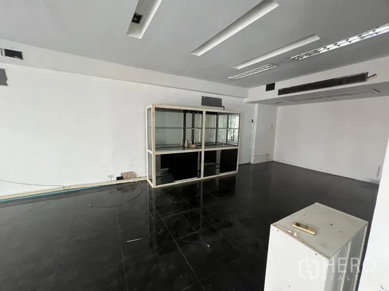 Retail Space for rent in Watthana, Bangkok - Retail unit featuring recessed lighting and a freestanding glass display cabinet on dark polished tiles.
