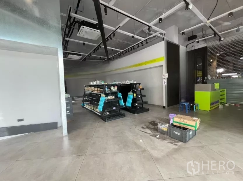 Retail Space for rent - Retail floor with display shelving, tiled flooring, track lighting and a service counter ready for use.