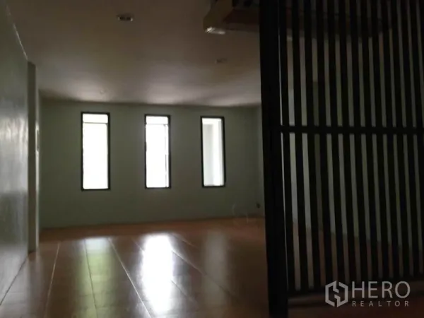 Home Office for rent or sale in Wang Thonglang, Bangkok - Open room with three narrow windows, light tile flooring, and a black slatted divider in a Bangkok home office.