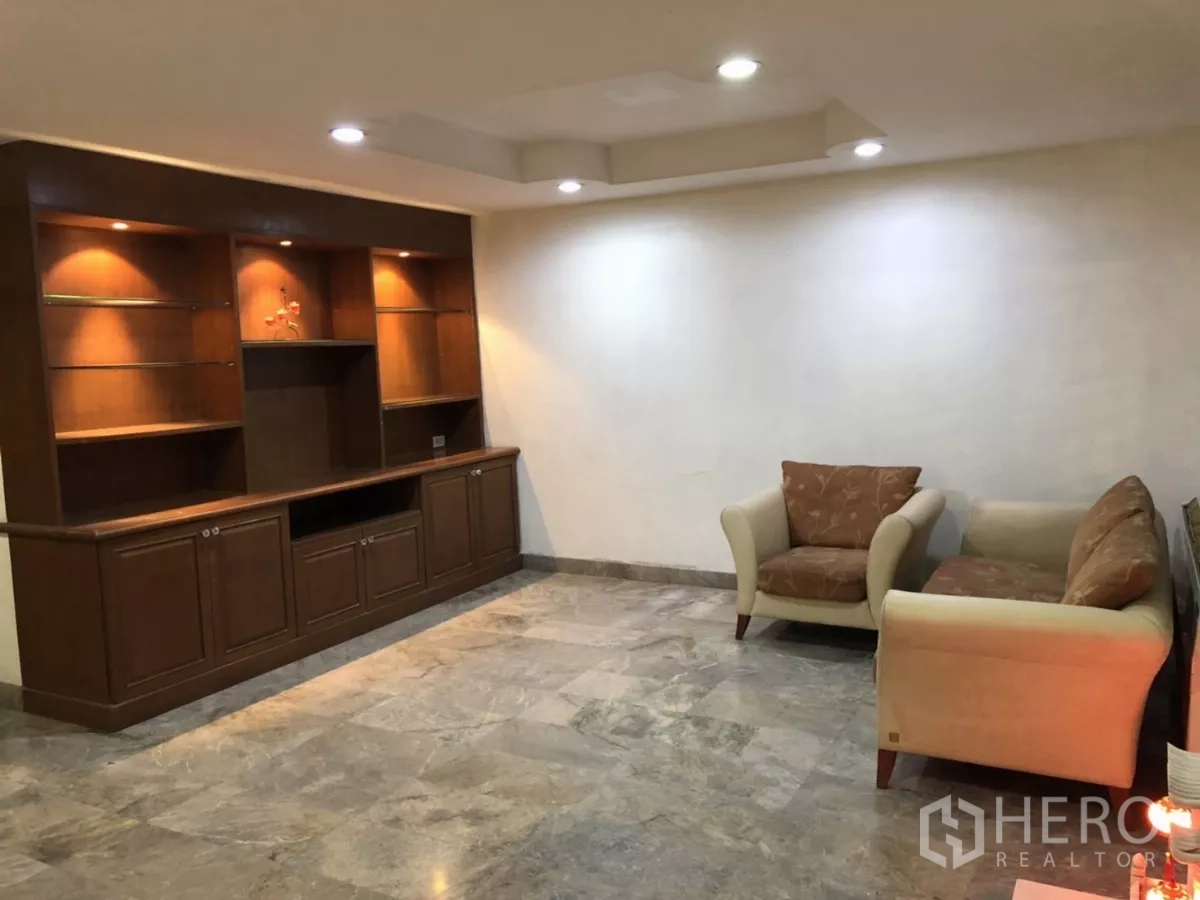 带办公室的家 出租在Phra Khanong, Bangkok - 客厅内置木质展示柜与座椅。