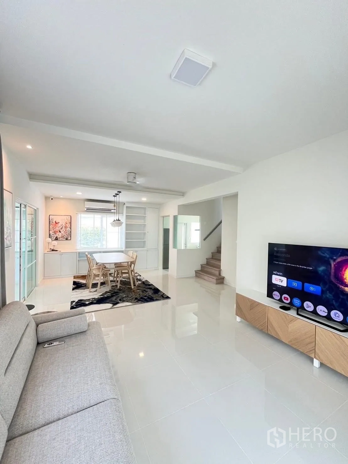 Detached House for rent in Bang Phli, Samut Prakan - Open-plan living and dining area with sofa, TV, and staircase.