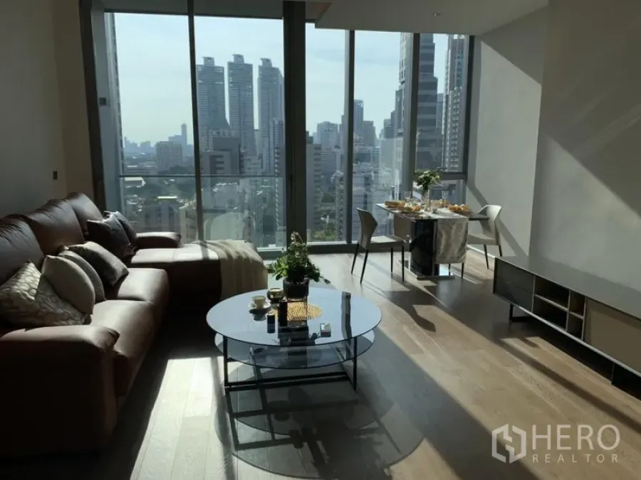 Condominium for rent or sale in Khlong Toei, Bangkok - Bright living and dining area with floor-to-ceiling windows and a Bangkok skyline view.