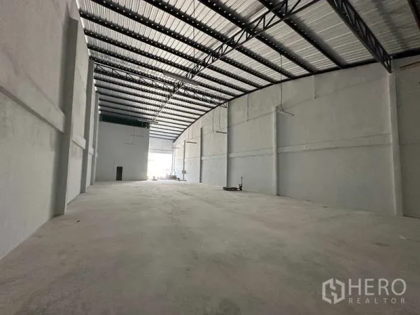 Warehouse for rent in Mueang Samut Sakhon, Samut Sakhon - Open warehouse bay with bright front entrance, ribbed metal roof, and exposed trusses.