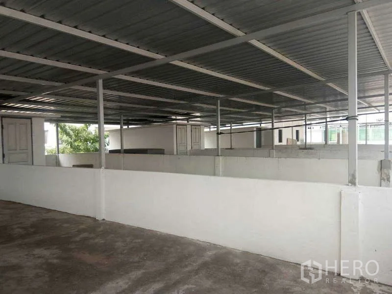 Shophouse for rent in Bang Na, Bangkok - Covered rooftop area with metal roof and partitioned sections for extra storage.