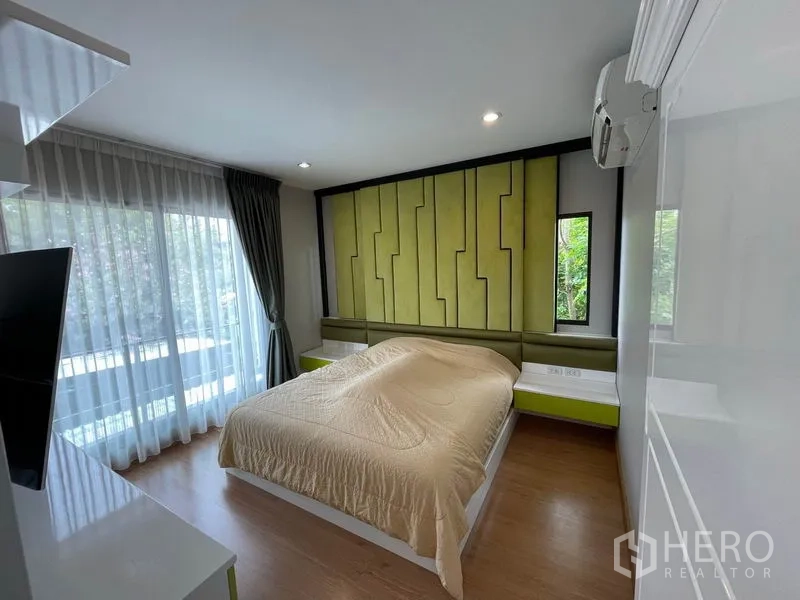 Detached House for rent - Master bedroom with green feature headboard and floor-to-ceiling windows.