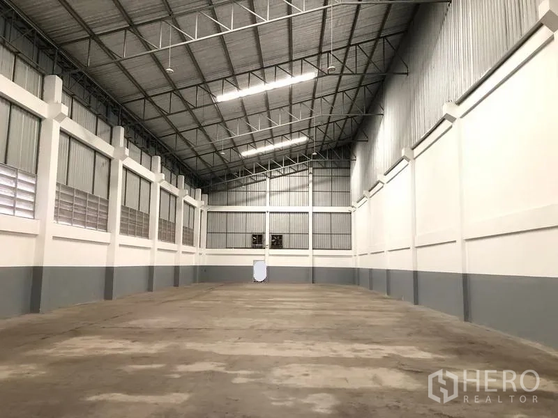 Factory for rent or sale in Bang Phli, Samut Prakan - High-clearance warehouse with steel truss roof, ventilation louvers and wide concrete floor.