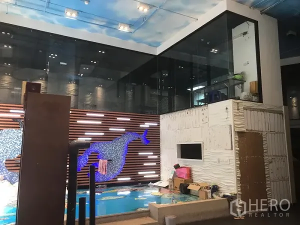 Retail Space for rent in Khlong Toei, Bangkok - Double-height retail space with mosaic whale feature wall, shallow pool display, and a glass room.